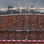 Denver Broncos fans wait out a rain and lightning delay before an NFL football game between the Baltimore Ravens and the Broncos in Denver on Thursday, Sept. 5, 2013. (AP Photo/Brennan Linsley)