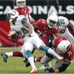 Miami Dolphins cornerback Sean Smith (24) is tackled by Arizona Cardinals guard Daryn Colledge (71) and William Powell (33) after running back an interception during the first half of an NFL football game, Sunday, Sept. 30, 2012, in Glendale, Ariz. (AP Photo/Paul Connors)