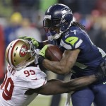  Seattle Seahawks' Marshawn Lynch tries to run past San Francisco 49ers' Aldon Smith during the second half of the NFL football NFC Championship game Sunday, Jan. 19, 2014, in Seattle. (AP Photo/Elaine Thompson)