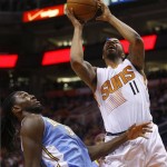 Phoenix Suns power forward Markieff Morris (11), right, draws the foul and scores on Denver Nuggets power forward Kenneth Faried (35) in the fourth quarter during an NBA basketball game on Friday, Nov. 8, 2013, in Phoenix. The Suns defeated the Nuggets 114-93. (AP Photo/Rick Scuteri)
