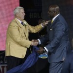 Former NFL football head coach Bill Parcells, left, shakes hands with presenter George Martin during the induction ceremony at the Pro Football Hall of Fame Saturday, Aug. 3, 2013, in Canton, Ohio. (AP Photo/Tony Dejak)
