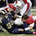 Arizona Cardinals quarterback Kevin Kolb, bottom right, is sacked by St. Louis Rams defensive tackle Jermelle Cudjo, bottom left, as Cardinals' Adam Snyder gets in on the play during the third quarter of an NFL football game, Thursday, Oct. 4, 2012, in St. Louis. Cudjo was charged with an unnecessary roughness penalty on the play. (AP Photo/Seth Perlman)