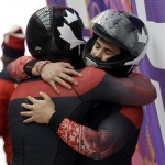 The team from Canada CAN-1, with Chris Spring, Timothy Randall, James McNaughton and Bryan Barnett, hug after their final run during the men's four-man bobsled competition final at the 2014 Winter Olympics, Sunday, Feb. 23, 2014, in Krasnaya Polyana, Russia. (AP Photo/Dita Alangkara)