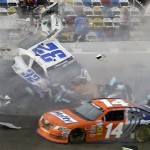 Kyle Larson (32) slides along the wall after hitting the catch fence as Eric McClure (14) goes low after the cars were involved in a multi-car crash on the final lap of the NASCAR Nationwide Series auto race at Daytona International Speedway, Saturday, Feb. 23, 2013, in Daytona Beach, Fla. (AP Photo/John Raoux)
