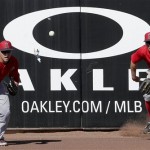 Los Angeles Angels left fielder Mike Trout, left, and center fielder Peter Bourjos chase after a triple hit by Seattle Mariners' Dustin Ackley during an exhibition spring training baseball game, Monday, Feb. 25, 2013, in Peoria, Ariz. (AP Photo/Charlie Riedel)
