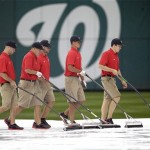 Members of the grounds crew squeegee water off the infield tarp during a rain delay before a baseball game between the Washington Nationals and Arizona Diamondbacks at Nationals Park, Thursday, June 27, 2013, in Washington.(AP Photo/Pablo Martinez Monsivais)