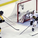 Boston Bruins center Patrice Bergeron (37) scores a goal past Chicago Blackhawks goalie Corey Crawford (50) and defenseman Brent Seabrook (7)during the second period in Game 3 of the NHL hockey Stanley Cup Finals in Boston, Monday, June 17, 2013. (AP Photo/Charles Krupa)