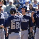 San Diego Padres' Jedd Gyorko (68) celebrates with teammates Will Venable, left, Chris Denorfia, center, and Kyle Blanks after he hit a grand slam during an exhibition spring training baseball game against the Seattle Mariners Friday, Feb. 22, 2013, in Peoria, Ariz. (AP Photo/Charlie Riedel)