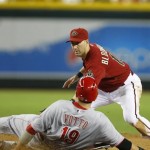Arizona Diamondbacks shortstop Willie Bloomquist, top, tags out Cincinnati Reds Joey Votto (19) who wastrying to stretch a double in the fifth inning during a baseball game on Sunday, June 23, 2013, in Phoenix. (AP Photo/Rick Scuteri)