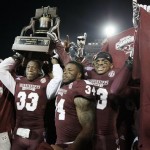  Mississippi State players Kivon Coman (33), Josh Robinson (34) and Michael Hodges, right, celebrate with the trophy after beating Rice in the Liberty Bowl NCAA college football game Tuesday, Dec. 31, 2013, in Memphis, Tenn. Mississippi State won 44-7. (AP Photo/Mark Humphrey)