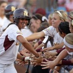 Arizona State's Alix Johnson, left, slaps hands with her teammates as she runs along the dugout after scoring against Florida in the second inning of a Women's College World Series championship series game in Oklahoma City, Monday, June 6, 2011. (AP Photo/Sue Ogrocki)