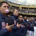 Atlanta Braves pitcher Luis Avilan, left, blows a bubble while standing for the national anthem before an exhibition spring training baseball game against the Detroit Tigers in Kissimmee, Fla., Sunday, March 3, 2013. (AP Photo/Phelan M. Ebenhack)