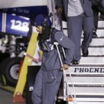 Seattle Seahawks' Richard Sherman walks on crutches on the team's arrival at Seattle-Tacoma International Airport, Monday, Feb. 3, 2014, in Seattle. The Seahawks defeated the Denver Broncos 43-8 in the Super Bowl on Sunday. (AP Photo/Elaine Thompson)
