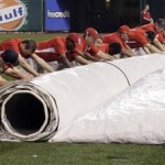 Members of the Busch Stadium grounds crew roll up the tarp in preparation for a baseball game between the St. Louis Cardinals and the Arizona Diamondbacks, Thursday, Aug. 16, 2012 in St. Louis. (AP Photo/Tom Gannam)