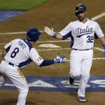 Italy's Tyler LaTorre (32) celebrates with Nick Punto (8) after scoring on a double by Anthony Granato during the second inning of a World Baseball Classic game against the United States on Saturday, March 9, 2013, in Phoenix. (AP Photo/Charlie Riedel)
