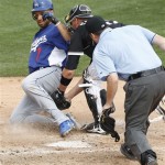 Los Angeles Dodgers' James Loney, left, is tagged out by Chicago White Sox catcher A.J. Pierzynski, center, as home plate umpire Dan Bellino, right, leans in for a closer look in the fifth inning of a spring training baseball game Monday, March 5, 2012, in Glendale, Ariz. (AP Photo/Paul Connors)