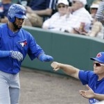 Toronto Blue Jays' Emilio Bonifacio, left, fist bumps with manager John Gibbons, right, after scoring a run during the third inning of an exhibition spring training baseball game against the Detroit Tigers, Saturday, Feb. 23, 2013, in Lakeland, Fla. (AP Photo/Charlie Neibergall)
