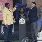 Former NFL football player Dave Robinson, left, and his son, David Robinson, unveil the bust during the induction ceremony at the Pro Football Hall of Fame Saturday, Aug. 3, 2013, in Canton, Ohio. (AP Photo/Tony Dejak)
