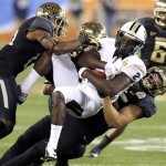 Central Florida wide receiver Jeff Godfrey (2) is tackled by, from left, Baylor's Terrell Burt, Eddie Lackey and Sam Holl during the first half of the Fiesta Bowl NCAA college football game, Wednesday, Jan. 1, 2014, in Glendale, Ariz (AP Photo/Ross D. Franklin)