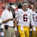 Southern California head coach Lane Kiffin looks over his list of plays during a timeout as Southern California quarterback Cody Kessler (6) looks on during the second quarter of an NCAA college football game Thursday, Aug. 29, 2013, in Honolulu. (AP Photo/Eugene Tanner)