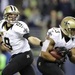 New Orleans Saints quarterback Drew Brees hands off to Pierre Thomas in the first half of an NFL football game against the Seattle Seahawks, Monday, Dec. 2, 2013, in Seattle. (AP Photo/Scott Eklund)