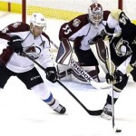 Pittsburgh Penguins' Chris Kunitz (14) works to control the puck against Colorado Avalanche's Paul Stastny (26) in front of Colorado Avalanche goalie Jean-Sebastien Giguere (35) during a first-period power play in an NHL hockey game in Pittsburgh Monday, Oct. 21, 2013. (AP Photo/Gene J. Puskar)