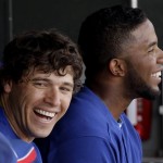 Texas Rangers' Ian Kinsler, left, and Elvis Andrus sit in the dugout during the second inning of a spring training baseball game against the Kansas City Royals Monday, March 5, 2012, in Surprise, Ariz. (AP Photo/Charlie Riedel)