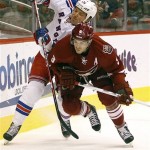 New York Rangers left-winger Ruslan Fedotenko, left, of Ukraine, battles Phoenix Coyotes defenseman Keith Yandle, right, for a loose puck in the first period of an NHL hockey game on Saturday, Dec. 17, 2011, in Glendale, Ariz. (AP Photo/Paul Connors)