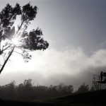 Clouds are seen rising behind as a broadcast camera operator stands atop a platform at the seventh tee before the first round at the Tournament of Champions PGA golf tournament, Sunday, Jan. 6, 2013, in Kapalua, Hawaii. Play was to have started two days earlier, but was delayed because of rain and high winds. (AP Photo/Elaine Thompson)