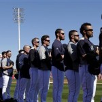 The Seattle Mariners line the baseline for the national anthem during an exhibition spring training baseball game against the San Diego Padres Friday, Feb. 22, 2013, in Peoria, Ariz. (AP Photo/Charlie Riedel)