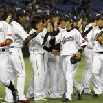 Japan's Hisayoshi Chono, center, and Yoshio Itoi, left, celebrate with teammates after defeating the Netherlands 10-6 in their World Baseball Classic second round game at Tokyo Dome in Tokyo, Tuesday, March 12, 2013. (AP Photo/Koji Sasahara)