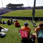 People lounge on the grass near the right field wall as they watch the sixth inning of an exhibition spring training baseball game between the Washington Nationals and the New York Mets in Port St. Lucie, Fla., Saturday, Feb. 23, 2013, in (AP Photo/Julio Cortez)
