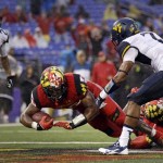 Maryland running back Brandon Ross, center, dives into the end zone for a touchdown against West Virginia cornerbacks Travis Bell (26) and Daryl Worley in the second half of an NCAA college football game in Baltimore, Saturday, Sept. 21, 2013. Maryland won 37-0. (AP Photo/Patrick Semansky)