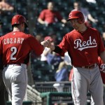 Cincinnati Reds third baseman Todd Frazier, right, and Zack Cozart celebrate after scoring on a Ryan Hanigan two-run double in the first inning of a spring training exhibition baseball game in Goodyear, Ariz., Friday, Feb. 22, 2013. (AP Photo/Paul Sancya)