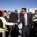 Oklahoma State coach Mike Gundy, center, is greeted by Fiesta Bowl committee members Kip Sullivan, left, and Marci Zimmerman, second from left, upon the team's arrival to play Stanford in the Fiesta Bowl NCAA college football game Jan. 2, on Monday, Dec. 26, 2011, at Sky Harbor International Airport in Phoenix. (AP Photo/Paul Connors)