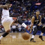 Chicago Bulls' Jimmy Butler, left, tries to block a pass by Memphis Grizzlies' Jerryd Bayless during the first half of an NBA preseason basketball game Monday, Oct. 7, 2013, in St. Louis. (AP Photo/Jeff Roberson)
