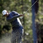 Tiger Woods hits out of the sand on the 11th hole during a practice round for the Masters golf tournament Wednesday, April 6, 2011, in Augusta, Ga. (AP Photo/Matt Slocum)
 