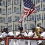Miami Heat's Chris Bosh, right, holds the NBA championship trophy during the celebration parade in Miami, Monday, June 24, 2013. Miami became the sixth franchise in NBA basketball history to win consecutive championships, after topping the San Antonio Spurs in this year's finals for the third title overall for the Heat franchise. (AP Photo/Javier Galeano)