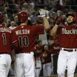 Arizona Diamondbacks' Cody Ross, right, arrives at home plate to celebrate his three-run home run against the Miami Marlins with teammates Didi Gregorius (1) and Josh Wilson (10) during the eighth inning of a baseball game on Wednesday, June 19, 2013, in Phoenix. The Diamondbacks defeated the Marlins 3-1. (AP Photo/Ross D. Franklin)