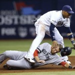 Boston Red Sox's Will Middlebrooks (16) slides under Tampa Bay Rays shortstop Yunel Escobar (11) after he was tagged out on a double play in the third inning in Game 4 of an American League baseball division series, Tuesday, Oct. 8, 2013, in St. Petersburg, Fla. (AP Photo/Mike Carlson)