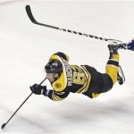 Boston Bruins left wing Brad Marchand (63) is tripped as he shoots on-goal after getting past New York Rangers defenseman Michael Del Zotto (4) during the second period in Game 1 of an NHL hockey playoffs Eastern Conference semifinal game in Boston, Thursday, May 16, 2013. (AP Photo/Charles Krupa)