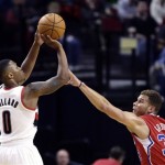 Portland Trail Blazers guard Damian Lillard, left, shoots over Los Angeles Clippers forward Blake Griffin during the first half of an NBA preseason basketball game in Portland, Ore., Monday, Oct. 7, 2013. (AP Photo/Don Ryan)
