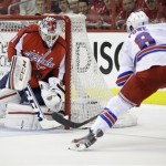Washington Capitals goalie Braden Holtby, left, makes a save against New York Rangers right wing Darroll Powe during the second period in Game 2 of an NHL hockey Stanley Cup first-round playoff series, Saturday, May 4, 2013, in Washington. (AP Photo/Evan Vucci)