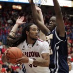 Arizona's Jesse Perry (32) tries to pass against the pressing defense of Northern Arizona's Ephraim Ekanem, right, under the basket during the first half of an NCAA college basketball game at McKale Center in Tucson, Ariz., Saturday, Dec. 3, 2011. (AP Photo/John Miller)