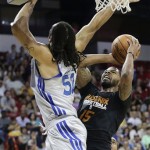 Phoenix Suns' Marcus Morris (15) puts up a shot against Golden State Warriors' Gary McGhee (52) in the fourth quarter of the NBA Summer League championship game, Monday, July 22, 2013, in Las Vegas. The Warriors won 91-77. (AP Photo/Julie Jacobson)