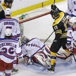 Boston Bruins left wing Milan Lucic (17) raises his stick to celebrate a goal by teammate Zdeno Chara (not shown) as New York Rangers goalie Henrik Lundqvist, center, falls onto his back during the second period in Game 1 of an NHL hockey playoffs Eastern Conference semifinal game in Boston, Thursday, May 16, 2013. (AP Photo/Charles Krupa)
