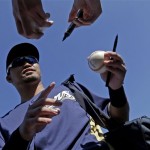 Milwaukee Brewers' Norichika Aoki signs autographs before an exhibition spring training baseball game against the Oakland Athletics Saturday, Feb. 23, 2013, in Phoenix. (AP Photo/Morry Gash)
