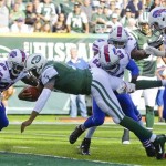 New York Jets quarterback Geno Smith (7) dives past Buffalo Bills' Da'Norris Searcy (25) and Aaron Williams (23) for a touchdown in the first half of an NFL football game Sunday, Sept. 22, 2013, in East Rutherford, N.J. (AP Photo/Seth Wenig)