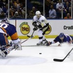 Pittsburgh Penguins' Sidney Crosby, second from left, assists Pascal Dupuis (9), right, in his goal past New York Islanders' Lubomir Visnovsky, second from right, during the first period of Game 3 of an NHL hockey Stanley Cup first-round playoff series on Sunday, May 5, 2013, in Uniondale, N.Y. (AP Photo/Seth Wenig)