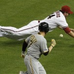 Arizona Diamondbacks' Joe Saunders, top, tries to field a bunt by Pittsburgh Pirates' Alex Presley, left, during the fifth inning of a baseball game Monday, April 16, 2012, in Phoenix. Presley reached on an infield hit on the play.(AP Photo/Ross D. Franklin)